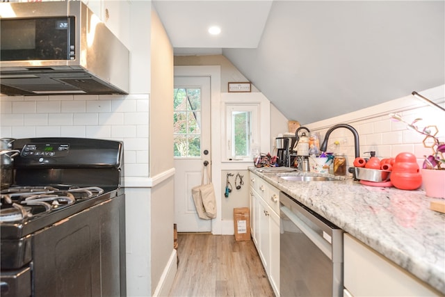 kitchen with light hardwood / wood-style floors, white cabinetry, vaulted ceiling, and appliances with stainless steel finishes