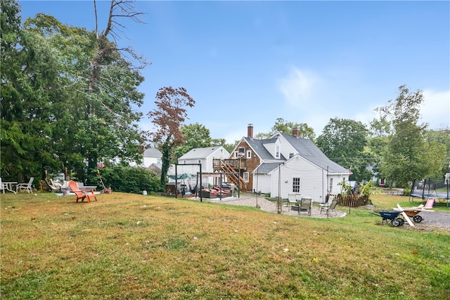 view of yard with a fire pit, a trampoline, and a patio