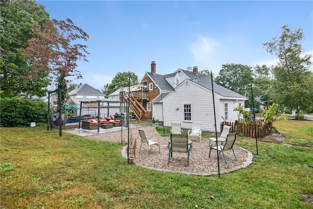 rear view of house featuring a deck, a yard, and a patio area