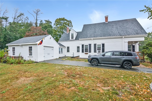 back of property with a garage and a yard