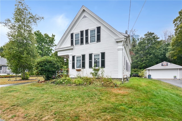 view of front of house with a front yard, a garage, and an outdoor structure