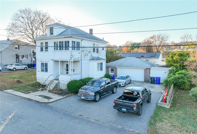 view of front of property with a garage, an outbuilding, and a balcony