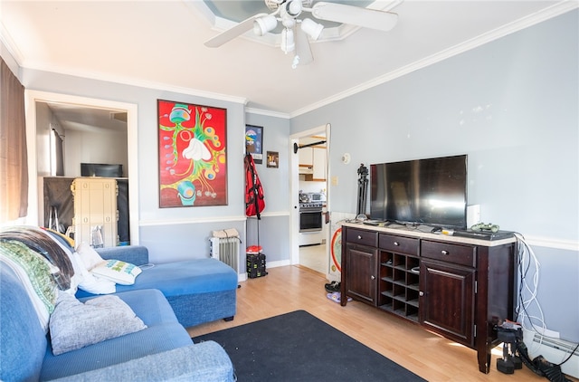 living room with light wood-type flooring, a baseboard radiator, ceiling fan, and crown molding