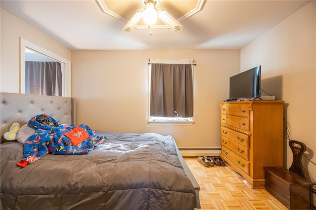 bedroom featuring ceiling fan, light parquet floors, and baseboard heating