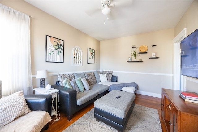 living room featuring ceiling fan and dark hardwood / wood-style floors