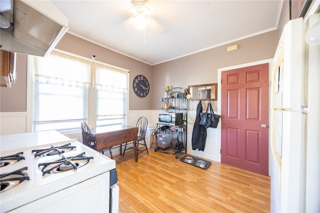 kitchen with light hardwood / wood-style floors, ceiling fan, white gas range oven, and ornamental molding