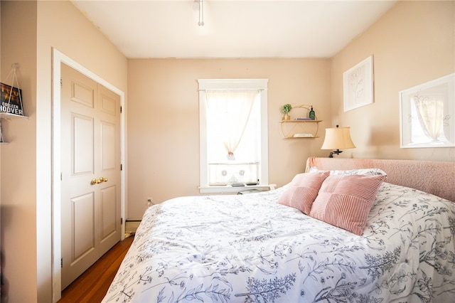 bedroom with dark hardwood / wood-style floors and a closet