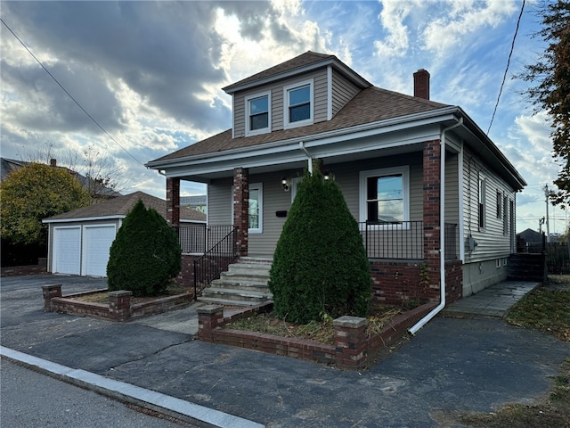 bungalow-style home with a garage, an outdoor structure, and a porch