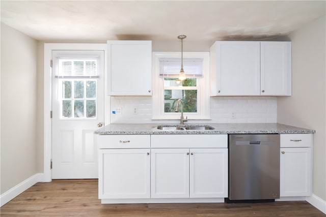 kitchen featuring plenty of natural light, stainless steel dishwasher, and white cabinets