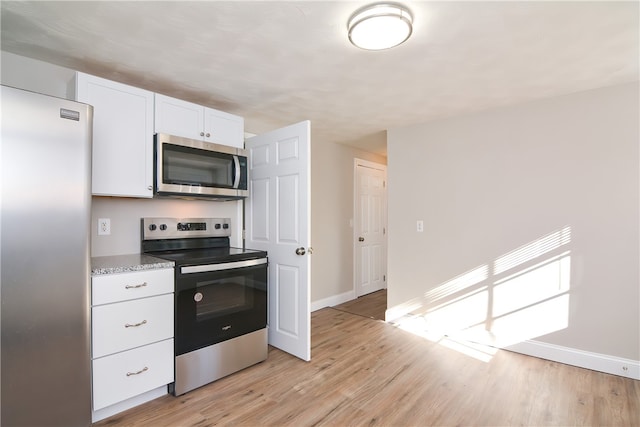 kitchen with stainless steel appliances, light hardwood / wood-style floors, white cabinets, and light stone counters