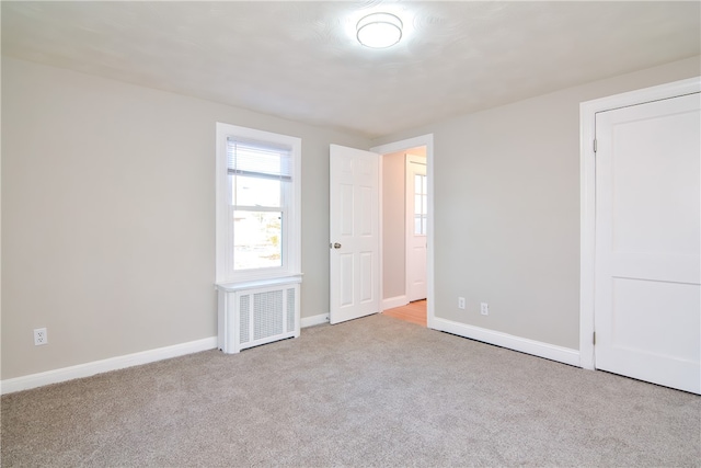 carpeted empty room featuring radiator