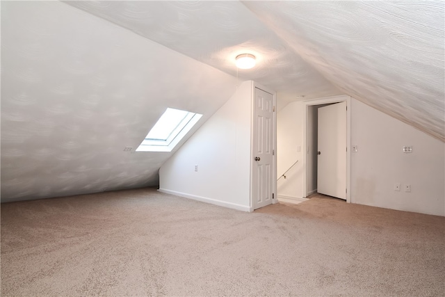 additional living space featuring lofted ceiling and light colored carpet