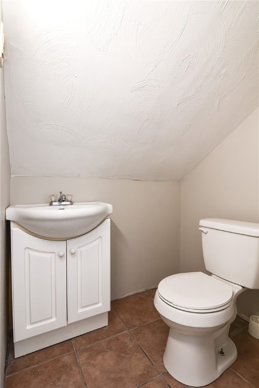 bathroom with tile patterned flooring, vanity, and toilet