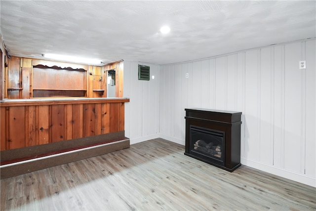 bar featuring light hardwood / wood-style floors and wooden walls