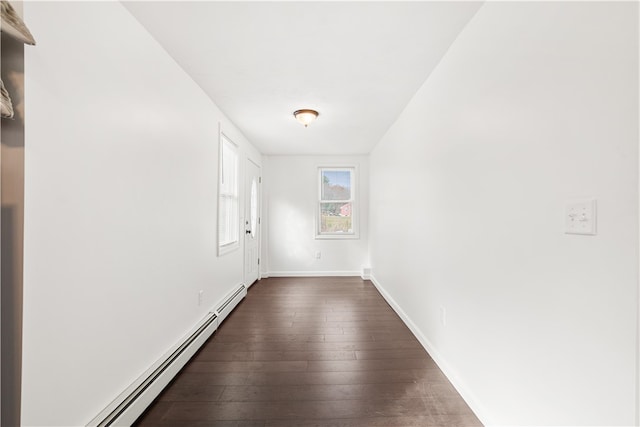 unfurnished room featuring dark hardwood / wood-style floors and a baseboard heating unit