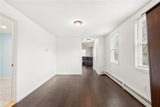 interior space with dark wood-type flooring and baseboard heating