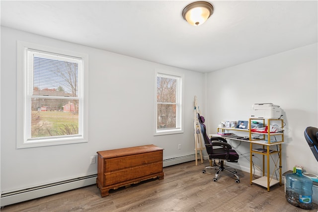 home office featuring a baseboard heating unit and wood-type flooring