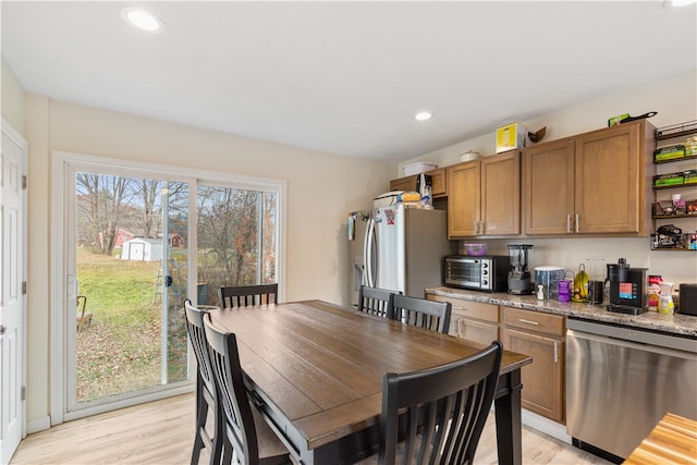 kitchen featuring stainless steel dishwasher, a healthy amount of sunlight, and light wood-type flooring