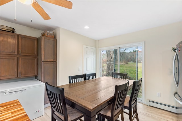 dining area featuring ceiling fan, a baseboard radiator, and light wood-type flooring