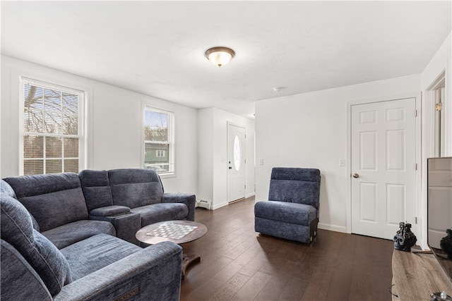 living room with dark wood-type flooring, a baseboard heating unit, and plenty of natural light