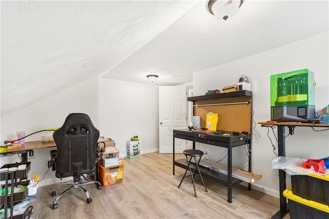 office space featuring light wood-type flooring and lofted ceiling