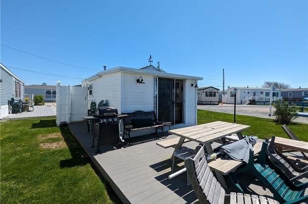 rear view of house with a lawn and a wooden deck