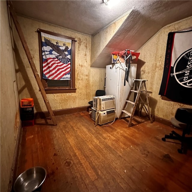 miscellaneous room featuring lofted ceiling and wood-type flooring