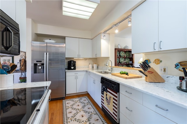 kitchen featuring sink, light stone counters, stainless steel refrigerator with ice dispenser, light hardwood / wood-style flooring, and white cabinets