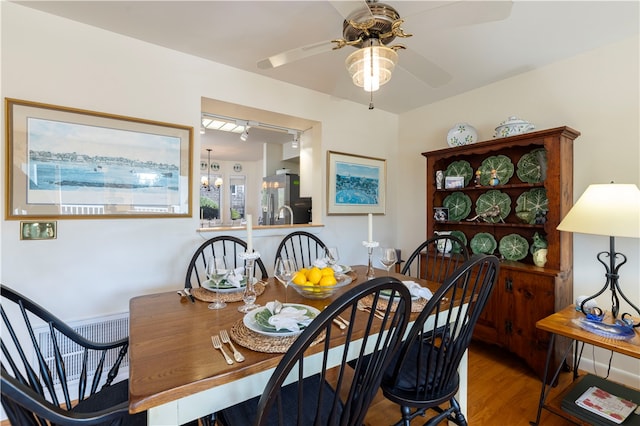 dining room with hardwood / wood-style flooring and ceiling fan with notable chandelier