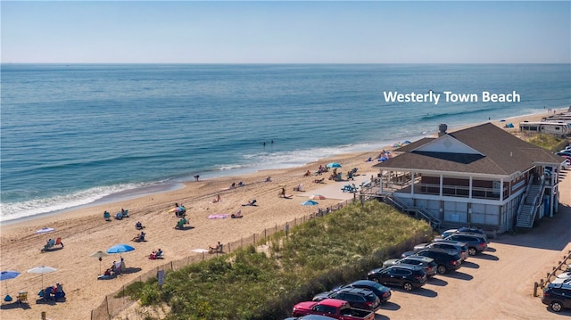 drone / aerial view featuring a beach view and a water view