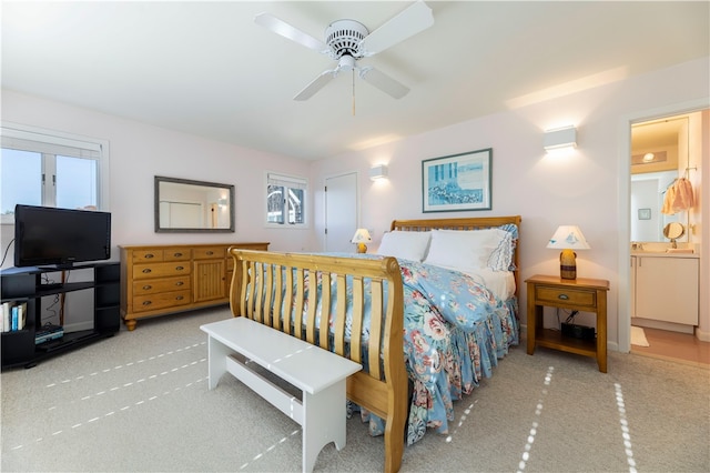 carpeted bedroom with ceiling fan and ensuite bath