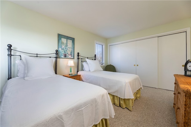 bedroom featuring light colored carpet and a closet