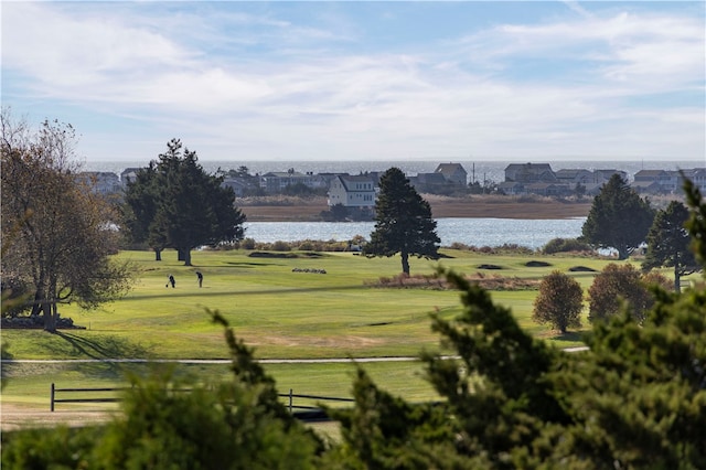 view of home's community with a water view and a lawn