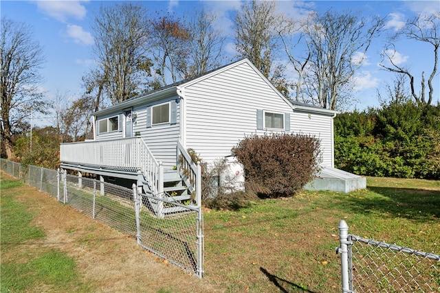 view of home's exterior featuring a lawn and a wooden deck