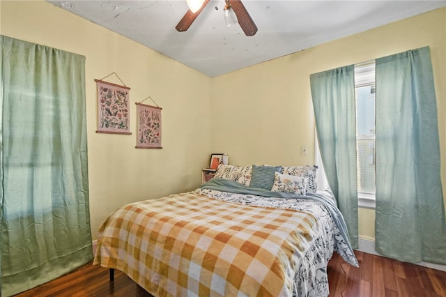 bedroom with dark hardwood / wood-style flooring and ceiling fan