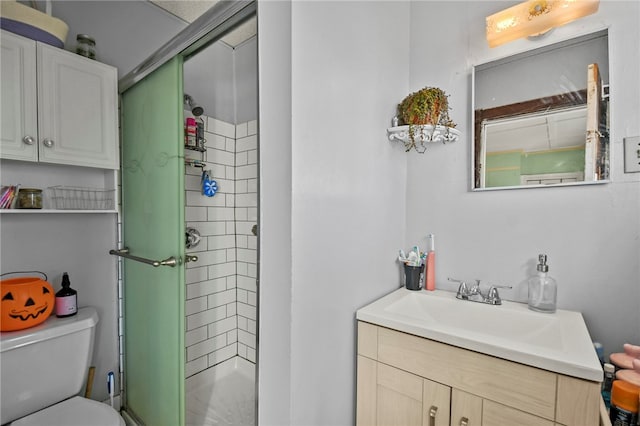 bathroom with toilet, vanity, and a shower with door