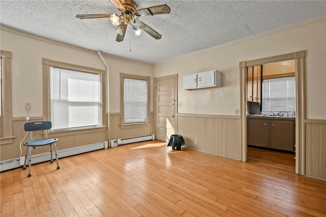 unfurnished room with light wood-type flooring and a textured ceiling