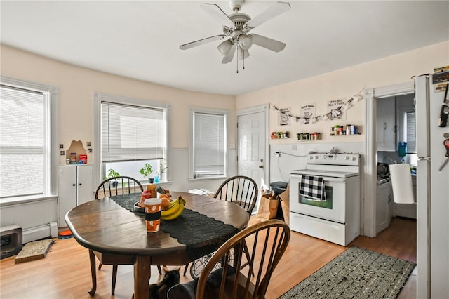 dining room with ceiling fan, light hardwood / wood-style flooring, and a baseboard heating unit