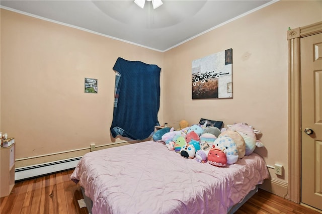 bedroom featuring ornamental molding, wood-type flooring, ceiling fan, and a baseboard heating unit