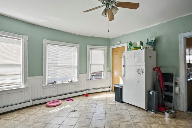 kitchen with a baseboard heating unit, plenty of natural light, ceiling fan, and white refrigerator