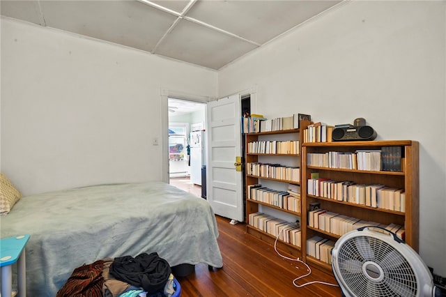 bedroom featuring dark wood-type flooring, a baseboard radiator, and white refrigerator