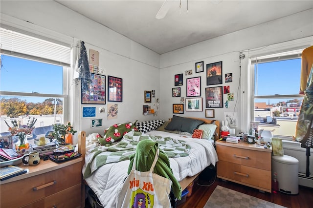 bedroom with dark hardwood / wood-style flooring and ceiling fan