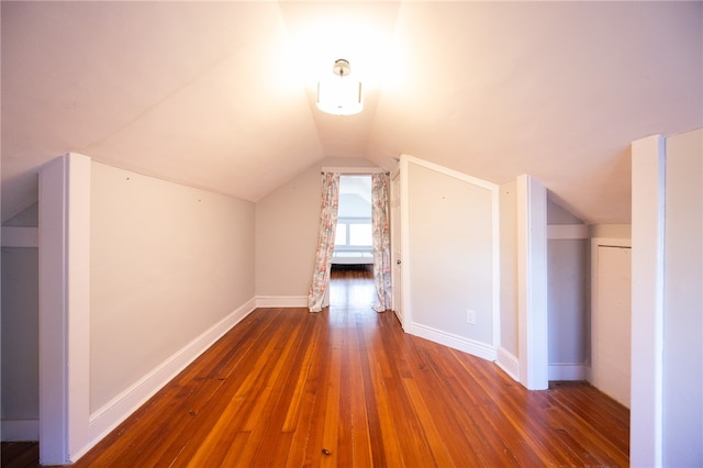 additional living space with dark hardwood / wood-style flooring and vaulted ceiling