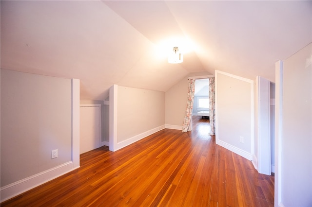 additional living space featuring lofted ceiling and hardwood / wood-style flooring