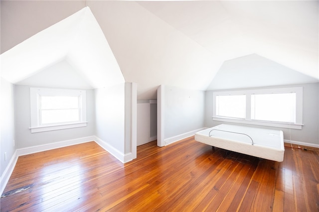 bonus room with wood-type flooring, plenty of natural light, and vaulted ceiling