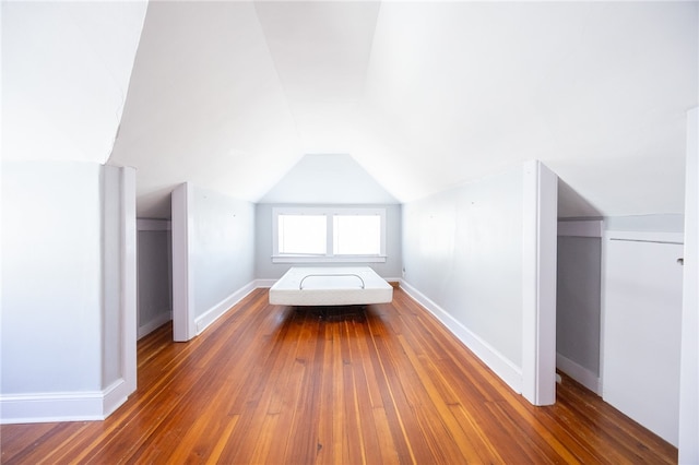 unfurnished bedroom featuring dark wood-type flooring and vaulted ceiling