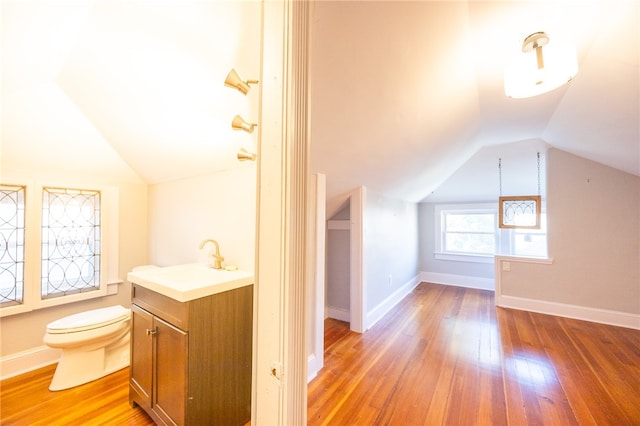 additional living space featuring sink, light hardwood / wood-style flooring, and lofted ceiling