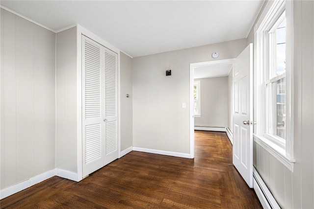 hall with a healthy amount of sunlight, baseboard heating, and dark hardwood / wood-style floors