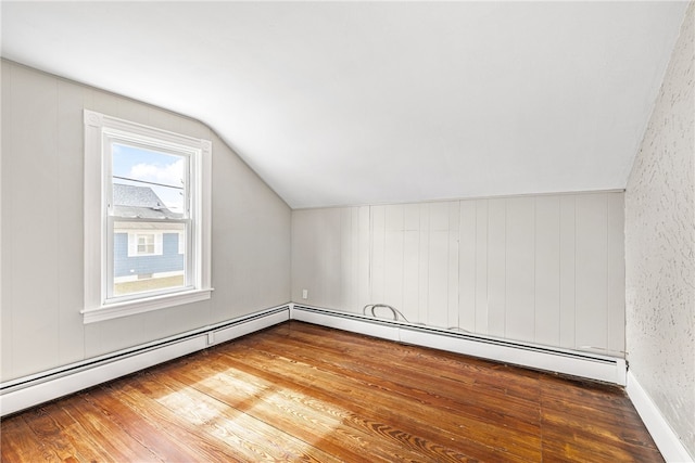 bonus room with baseboard heating, hardwood / wood-style flooring, and vaulted ceiling