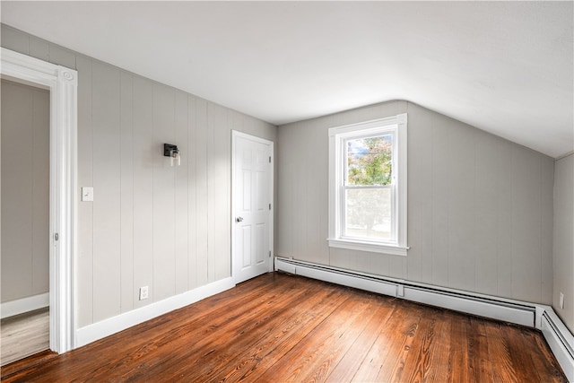 additional living space featuring baseboard heating, lofted ceiling, hardwood / wood-style flooring, and wood walls